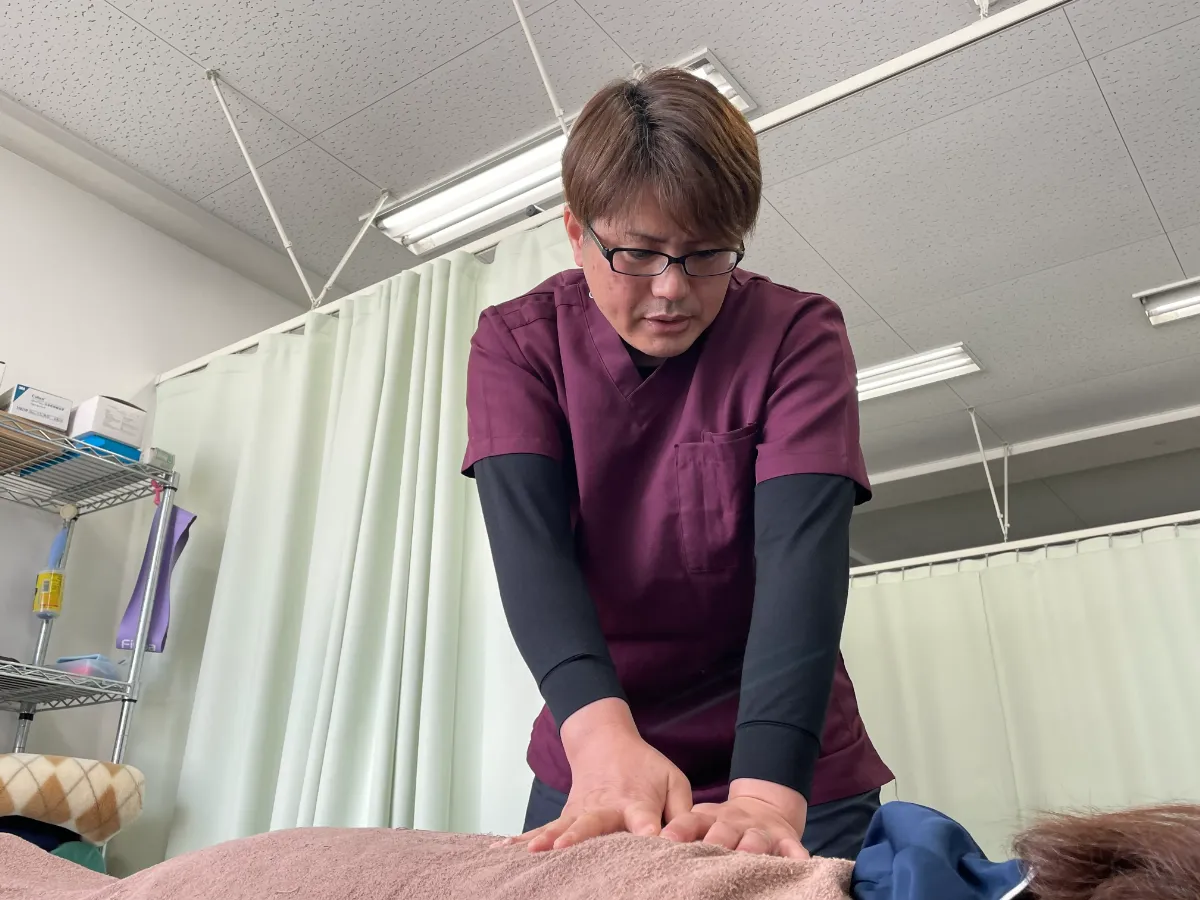 京田辺市松井山手のまえだ整骨院で、院長がカイロプラクティックと整体の施術をしている様子